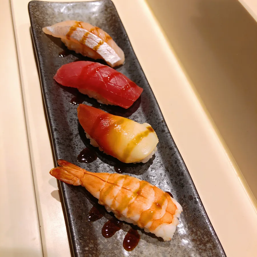 Nigiri di salmone, tonno, ricciola e gambero su piatto di pietra