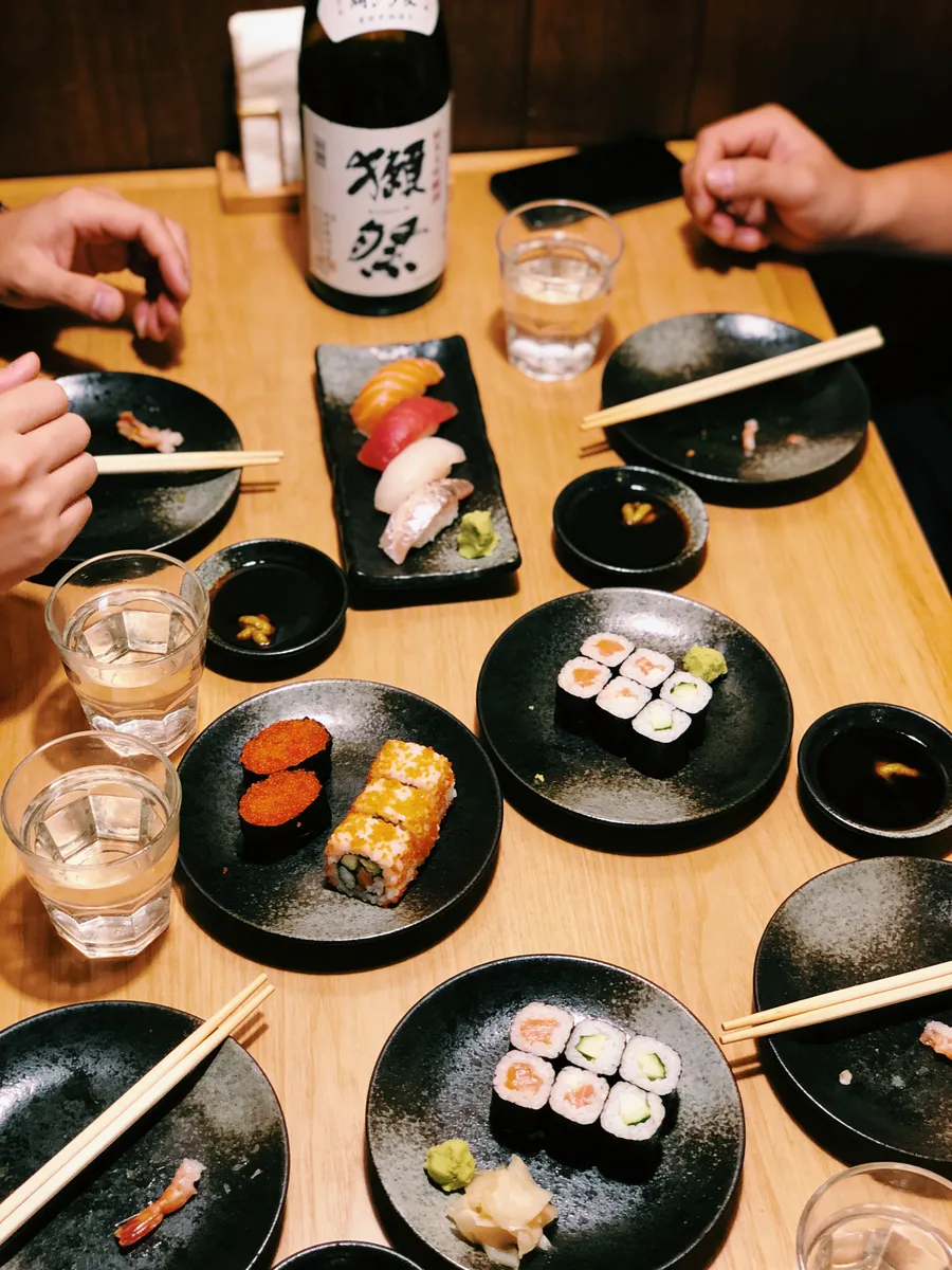 Un tavolo con piatti di sushi e sake